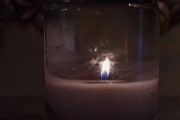 Candle burning inside a small jar. A jar with burning candle inside