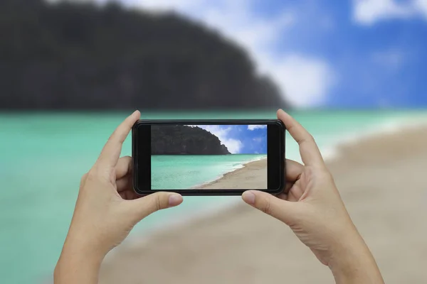 Hand som håller smartphone med vit blank skärm över suddig bea — Stockfoto