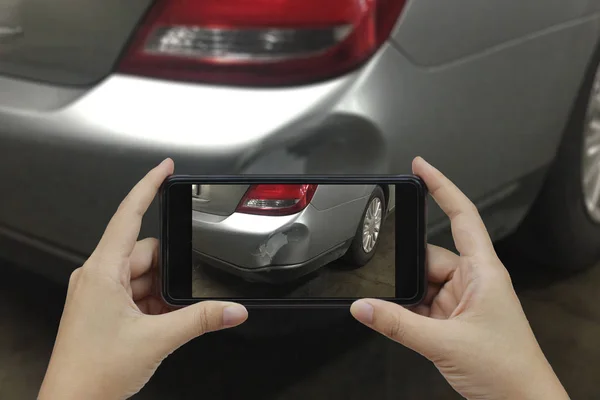 Mão segurando telefone inteligente tirar uma foto na cena de um carro cras — Fotografia de Stock