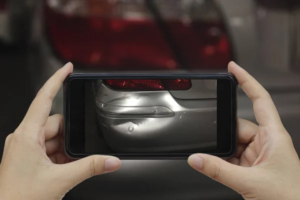 Mão segurando telefone inteligente tirar uma foto na cena de um carro cras — Fotografia de Stock