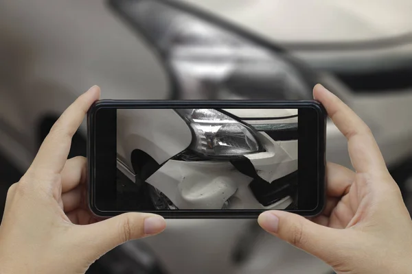 Mão segurando telefone inteligente tirar uma foto na cena de um carro cras — Fotografia de Stock