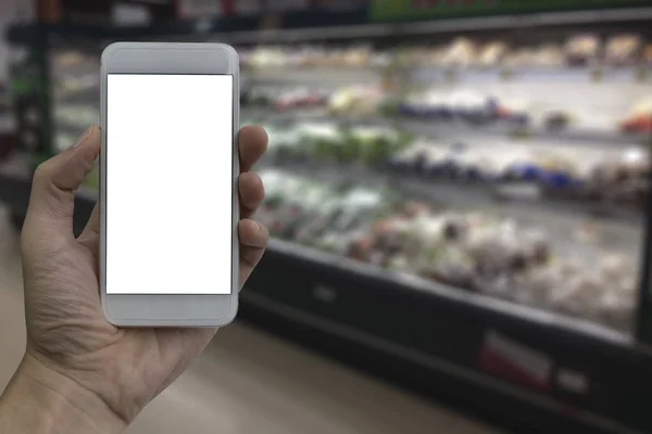 Mão segurando smartphone com tela branca em branco sobre sup desfocado — Fotografia de Stock