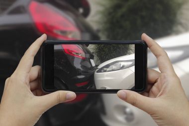 Akıllı telefon almak bir fotoğraf bir araba cras olay yerinde tutan el