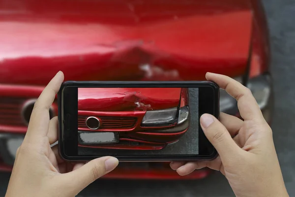 Mão segurando telefone inteligente tirar uma foto na cena de um carro cras — Fotografia de Stock