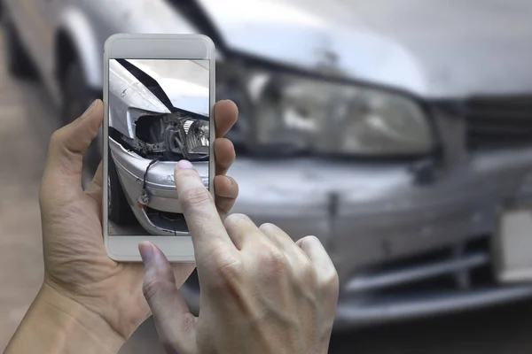 Hand met slimme telefoon nemen een foto op het toneel van een auto-cras — Stockfoto
