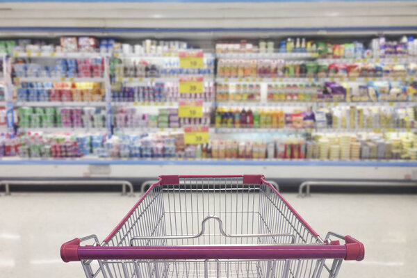 Supermarket aisle with empty shopping cart