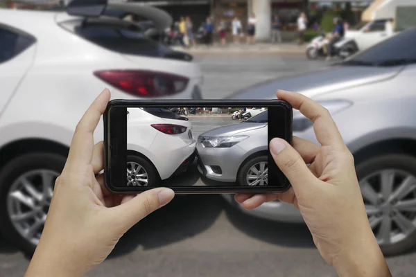Akıllı telefon almak bir fotoğraf bir araba cras olay yerinde tutan el