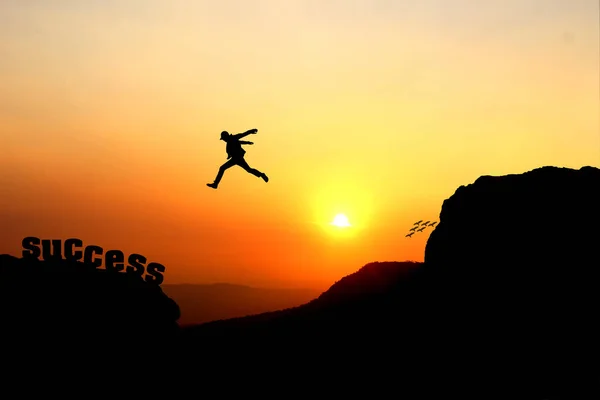 Silhouette of a man jumping over the cliff