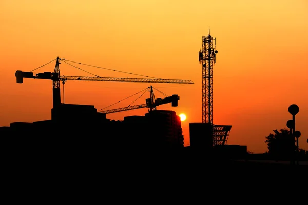 Silhouet kraan bouw bouwen bij zonsondergang — Stockfoto