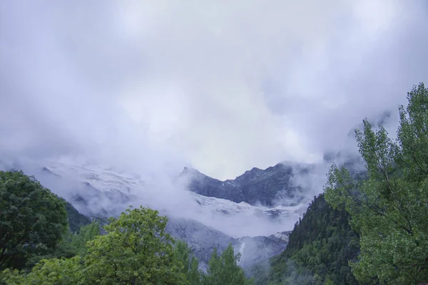 Das wunderschöne Bergpanorama ist von Nebel bedeckt. Wolken liegen auf Bergen. Bergfluss. — Stockfoto