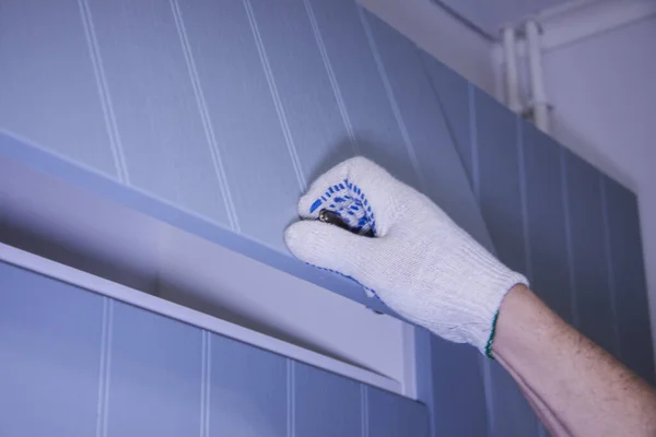 Manos de trabajo masculinas en guantes blancos con destornillador. Montaje de armarios de cocina . — Foto de Stock