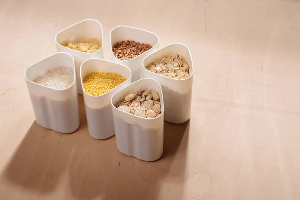 Coleta de cereais, grãos: arroz, aveia, trigo sarraceno, painço, mesa de madeira, cozinha do país, capacidade branca , — Fotografia de Stock