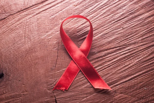 Red ribbon on the wooden background — Stock Photo, Image