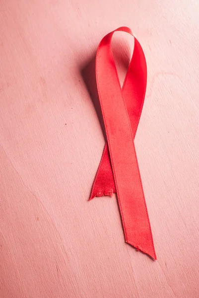 Red ribbon on the wooden background — Stock Photo, Image