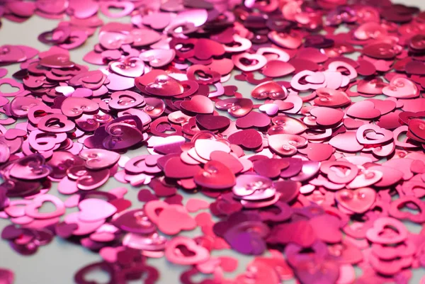 Confetti en forma de corazones esparcidos sobre la mesa . — Foto de Stock