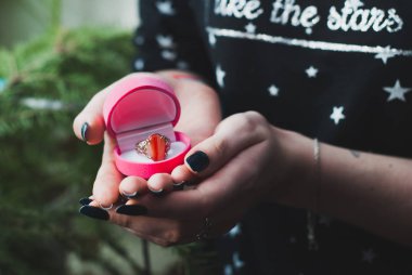 Bir halka ile pembe kutu tutan kız,