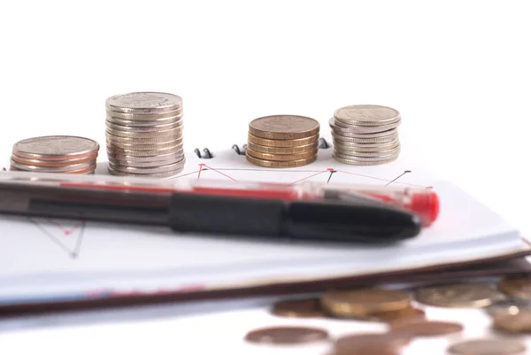 Fechamento pilha de moedas, caneta e bloco de notas no fundo branco . — Fotografia de Stock