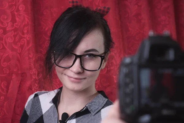 Kobiece młody blogger strzela sobie w aparacie, Ładna Brunetka w okularach, styl życia vlog — Zdjęcie stockowe