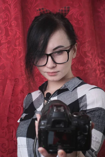 A young female blogger shoots himself on camera, pretty brunette in glasses, lifestyle vlog — Stock Photo, Image