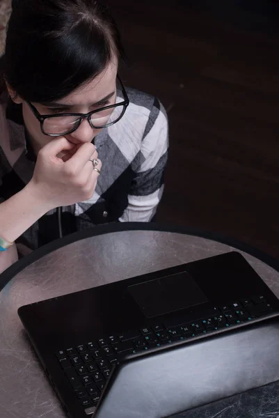 Linda chica trabajando en el ordenador portátil en casa, morena en gafas negras — Foto de Stock