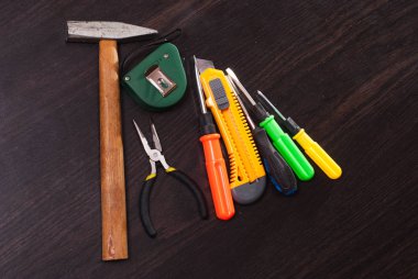 Ahşap arka plan üzerinde oluşturma araçları tamir kiti, parlak Tornavidalar, çekiç, yeni bıçak,