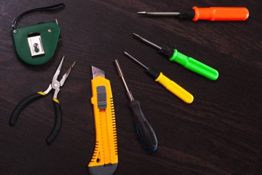 Ahşap arka plan üzerinde oluşturma araçları tamir kiti, parlak Tornavidalar, çekiç, yeni bıçak,