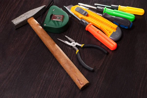 Ferramentas de construção em fundo de madeira, kit de reparação, chaves de fenda brilhantes, martelo, faca utilitário , — Fotografia de Stock