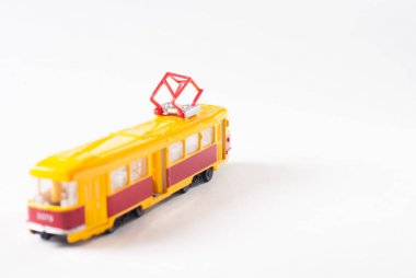 Beyaz zemin üzerine sarı oyuncak tramvay,