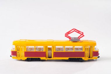 Beyaz zemin üzerine sarı oyuncak tramvay,