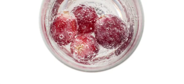 Красный виноград с пузырьками в стакане соды — стоковое фото