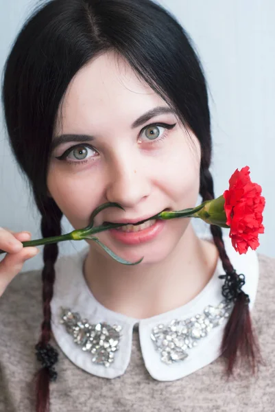 Playful girl holding a red carnation, — Stock Photo, Image