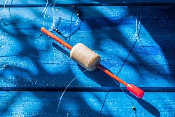Fishing line with lead and float on a blue background,