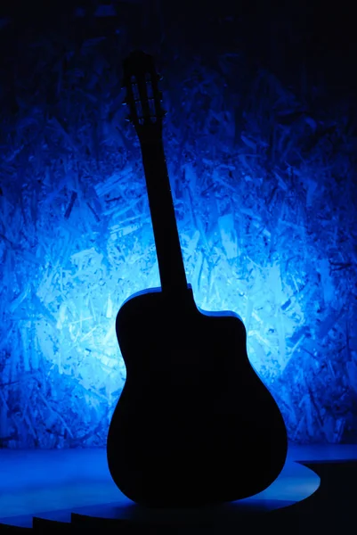 La silhouette è la classica chitarra acustica su fondo blu , — Foto Stock