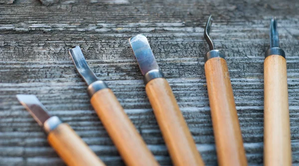 Gereedschap voor hout snijwerk op een oude houten achtergrond — Stockfoto