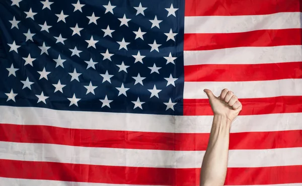 Tummen upp på bakgrunden av den amerikanska flaggan — Stockfoto