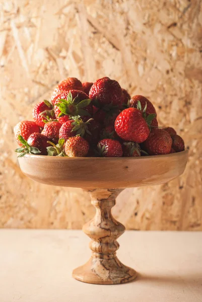 Fresh strawberries in wooden kitchenware, wooden background, — Stock Photo, Image