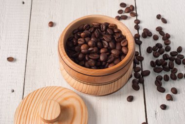 Eski ahşap masa üzerinde kahve çekirdekleri ile ahşap kase,