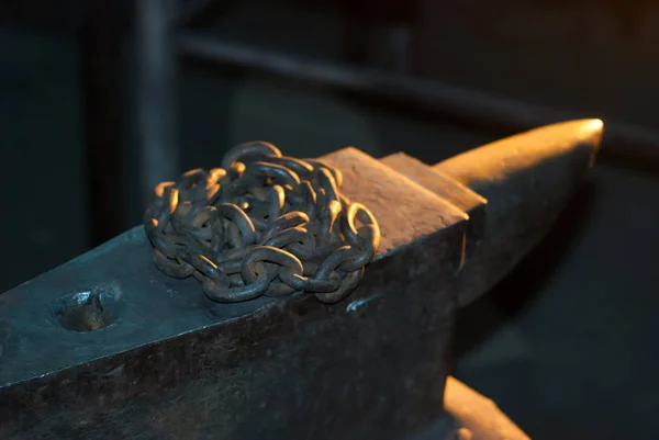 在铁匠铺里铁砧上生锈的铁链 — 图库照片