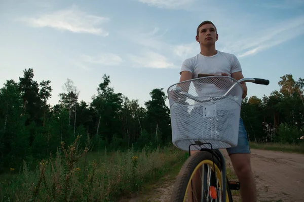 Telefonda gökyüzüne karşı bir bisikletçi bakar,