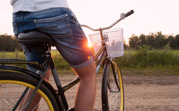 Стильний хлопець на велосипеді на заході сонця, дозвілля — стокове фото