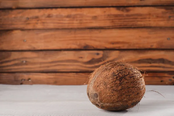 Kokos na staré dřevěné pozadí, bílé dřevo — Stock fotografie