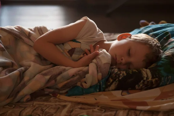 Enfant de six ans qui dort au lit le matin — Photo