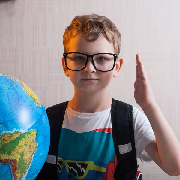 Gözlüklü, bir küre tutan küçük çocuk portresi. Dünya ile inek