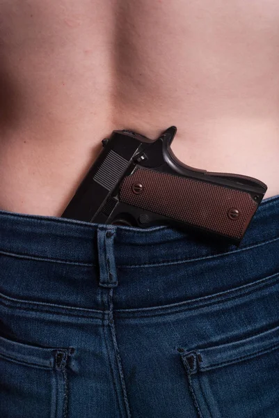 Девушка-преступница с пистолетом в поясе, незаконное хранение оружия , — стоковое фото