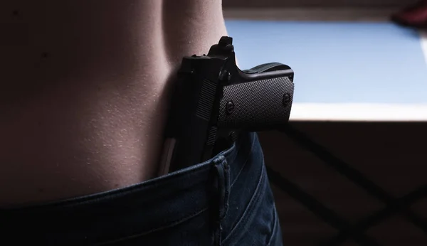 Девушка-преступница с пистолетом в поясе, незаконное хранение оружия , — стоковое фото