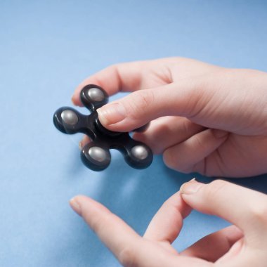 Kadınların elleri spinner mavi bir arka plan üzerinde twist.