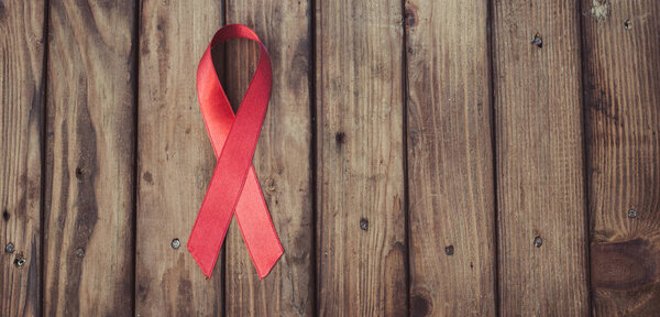 Red ribbon on wooden background,