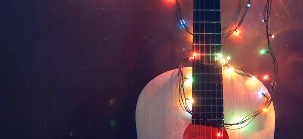 Oude akoestische gitaar met een krans op grunge achtergrond, — Stockfoto