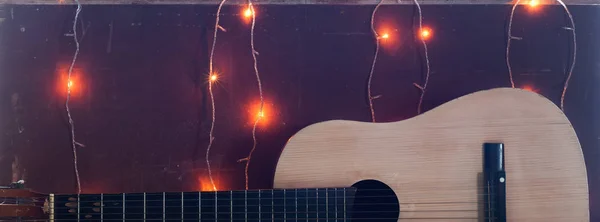 Gammal gitarr på bakgrunden av jul ljus, — Stockfoto
