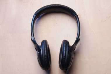 Ahşap arka planda siyah kulaklıklar.